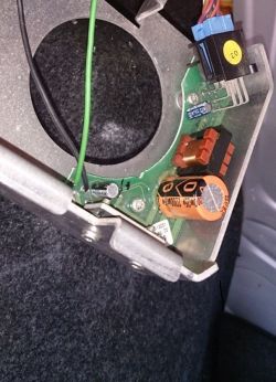 Zbliżenie płytki elektroniki w obudowie z dużym okrągłym otworem, przewodami i niebieskim złączem