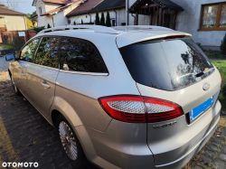A silver Ford Mondeo station wagon parked on a driveway next to a house.