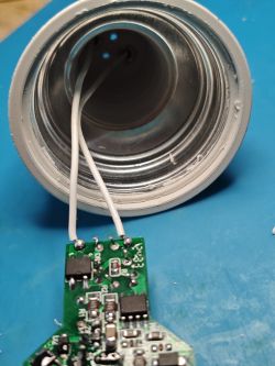 Inside view of LED bulb with PCB and two white wires soldered to it