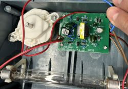 Wnętrze urządzenia z płytką elektroniczną i lampą UV.
