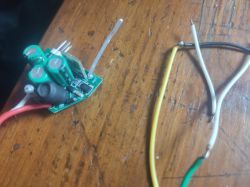 Electronic module with several wires on a wooden table.