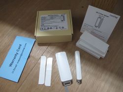 LoraTap Wi-Fi Door Sensor Kit LoraTap Wi-Fi door sensor kit on a wooden surface, including a user guide, warranty card, mounting tapes, and a sensor.