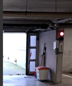 Underground Parking with Red Signal Light Underground parking with open doors and red signal light.
