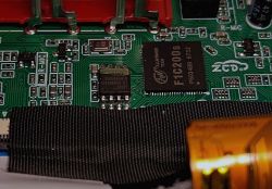 Close-up of radio PCB with Allwinner F1C200s chip, 25QH64DHIQ SPI flash, and LCD ribbon cable