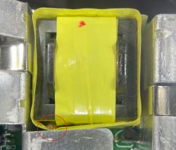 Zbliżenie na żółtą taśmę na elemencie elektronicznym, widoczne uszkodzenia