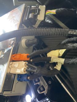 Złącza i kable w samochodzie Peugeot 208 II z widocznym systemem multimedialnym.