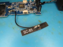 PCB with SC-85 labeled antenna wire Electronic module with antenna wire and label SC-85 on a blue work surface