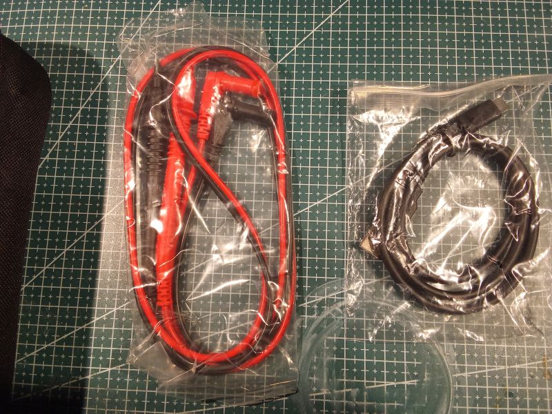 Przewody pomiarowe i kabel USB-C zapakowane w plastikowe woreczki strunowe
