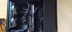 Wnętrze komputera z chłodzeniem cieczą, karta graficzna GEFORCE RTX pośrodku i przewodami cieczy po prawej stronie.