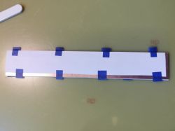 PCB board with printed paper aligned and taped with blue painter's tape