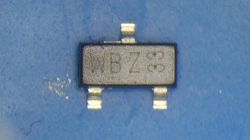 Zbliżenie tranzystora PMV16XN na niebieskim tle.