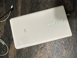 Modem ZTE MC889 z widocznymi świecącymi diodami LED na zielono.