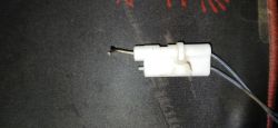 Zbliżenie na iskrownik piecyka gazowego z widocznym zakrzywieniem elektrody
