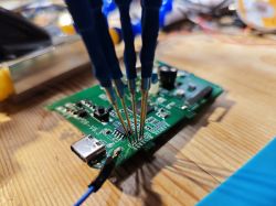 Close-up of a circuit board with attached test probes.