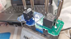 Two Aubess smart sockets with blue PCBs and relays on a workbench.