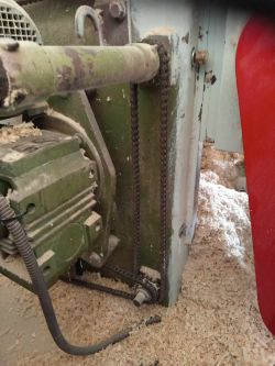 Widok na mechanizm strugarki dwustronnej z łańcuchem i korbą.