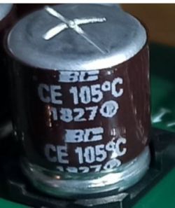 Zbliżenie na kondensator elektrolityczny z oznaczeniami.