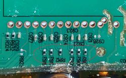 Zbliżenie na płytkę PCB z sześcioma oznaczonymi rezystorami 100R