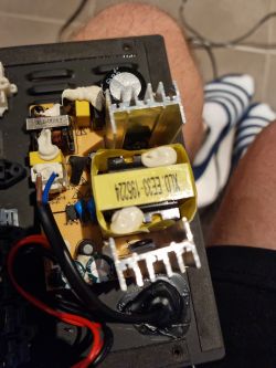Close-up of a speaker's interior showing a circuit board with electronic components and metal heat sinks.