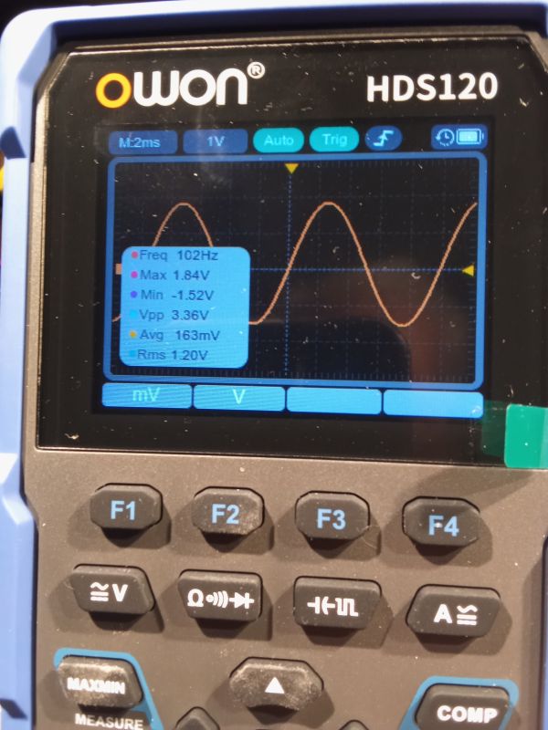 Przenośny oscyloskop OWON HDS120 wyświetlający przebieg sinusoidalny i jego parametry