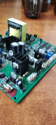 Płyta drukowana z kondensatorami, radiatorami i elementami elektronicznymi na blacie.