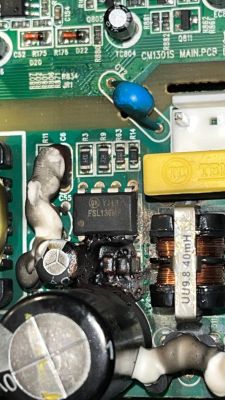 Nahaufnahme einer beschädigten Leiterplatte mit FSL136MR-Chip und mehreren verbrannten Bauteilen.