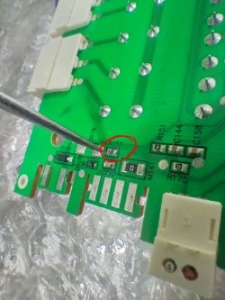 Damaged R157 Resistor on Green PCB Close-up of a PCB with a damaged surface-mounted resistor marked R157