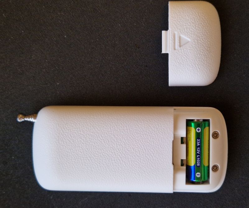 Back of RF remote with battery cover removed and 23A 12V battery visible