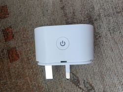 White Minimalist Plug on Carpet White plug with power button on carpet.