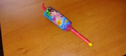 Colorful Chupa Chups raspberry-flavored lollipop on a wooden table.