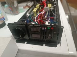 Przetwornica DC12V/AC230V z otwartą obudową i widocznym okablowaniem i elementami elektronicznymi.