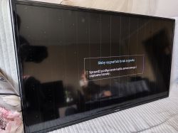 Telewizor Samsung z pionowymi pasami i artefaktami na ekranie.