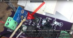 Close-up of a PCB with a relay module showing the process of removing an SMD capacitor from the RX pin.