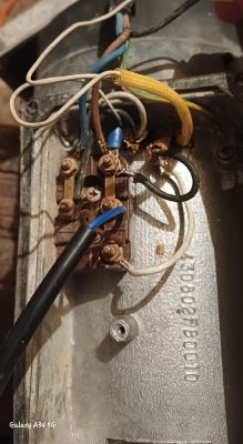 Zbliżenie na połączenia elektryczne jednofazowego silnika z widocznymi przewodami