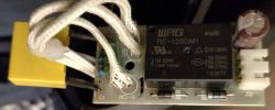 Close-up of an electric circuit board from a kettle with visible wires, capacitor, and relay.