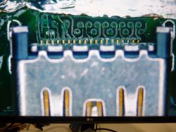 Zbliżenie na płytkę drukowaną PlayStation 5 z brakującym elementem w zaznaczonym miejscu.