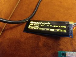 OLED display showing Radio Pogoda and track info with bitrate and codec details