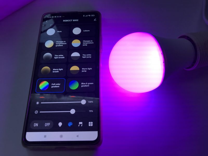 Controlling a Colorful LED Bulb with a Mobile App Smartphone with an app controlling a colorful LED bulb glowing purple.