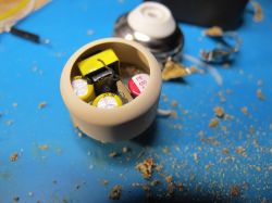 Close-up of the inside of an electronic component with removed casing, showing capacitors.