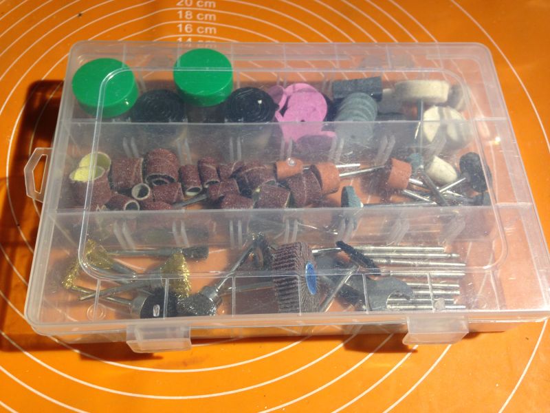 Przezroczyste pudełko z różnorodnymi akcesoriami do szlifierki.