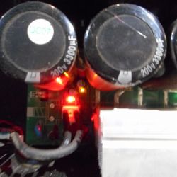 Close-up of the interior of a TSA4-1300 amplifier with visible capacitors and LED lights.