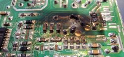 Spalona płytka PCB z widocznymi uszkodzeniami w okolicy elementów U5 i R2