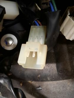 Biały złącze elektryczne z dwoma pinami podłączone do przewodów w motocyklu Yamaha.