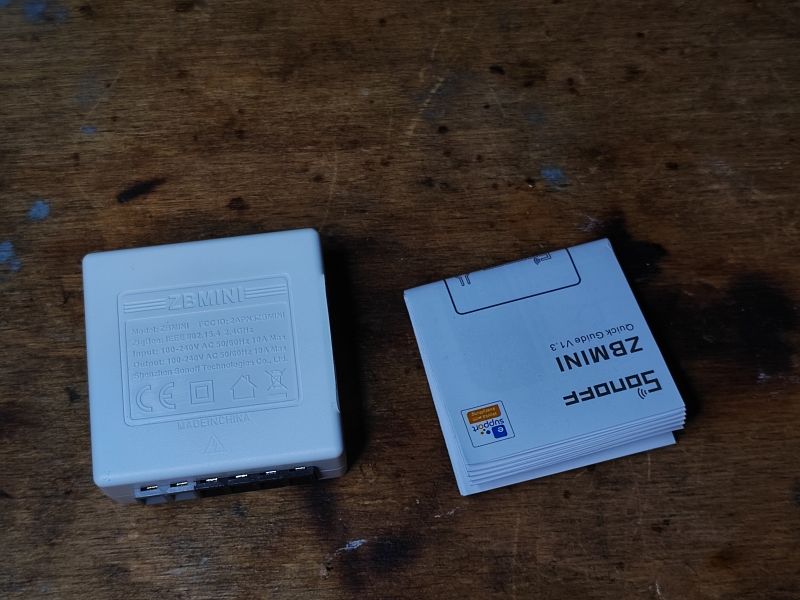 Sonoff ZBMini with Manual Sonoff ZBMini relay with manual on a wooden table