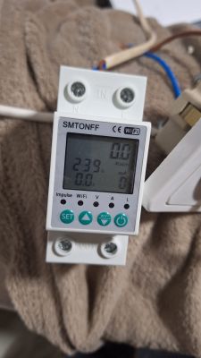 SMTONFF measuring device with a digital display showing current and voltage values.