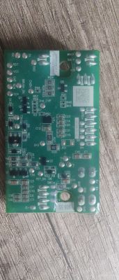 Płytka drukowana z różnymi elementami elektronicznymi na drewnianym tle.