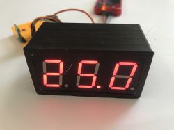 Close-up of a prototype board with a PIC18F2550 microcontroller, 7-segment display, and a connected potentiometer set as an input voltage source.