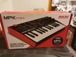 Pudełko kontrolera MIDI AKAI Professional MPK Mini na stole w pomieszczeniu magazynowym.