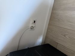 Gniazdka elektryczne i gniazdo na kabel dźwiękowy na białej ścianie.