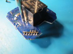 Close-up of PCB with Relay Close-up of a blue PCB with a relay and a screwdriver.